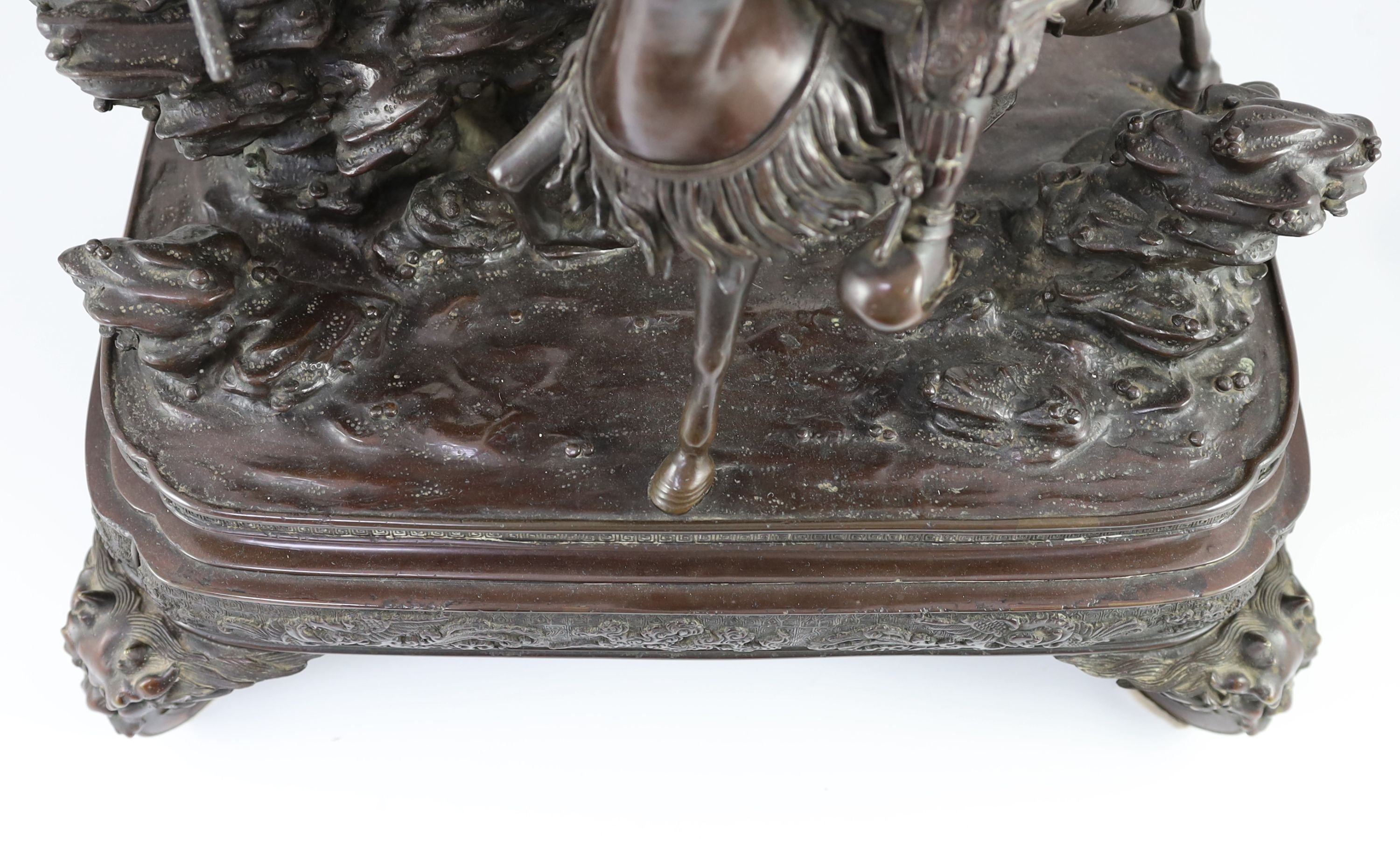 An impressive Japanese bronze group of an oni attacking a Samurai on horseback, Meiji period, 58cm high 49.5cm wide